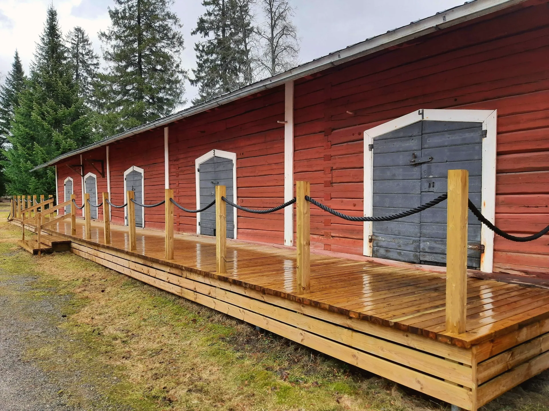 Accessible boardwalk style deck with rope guardrail built beside a heritage building
