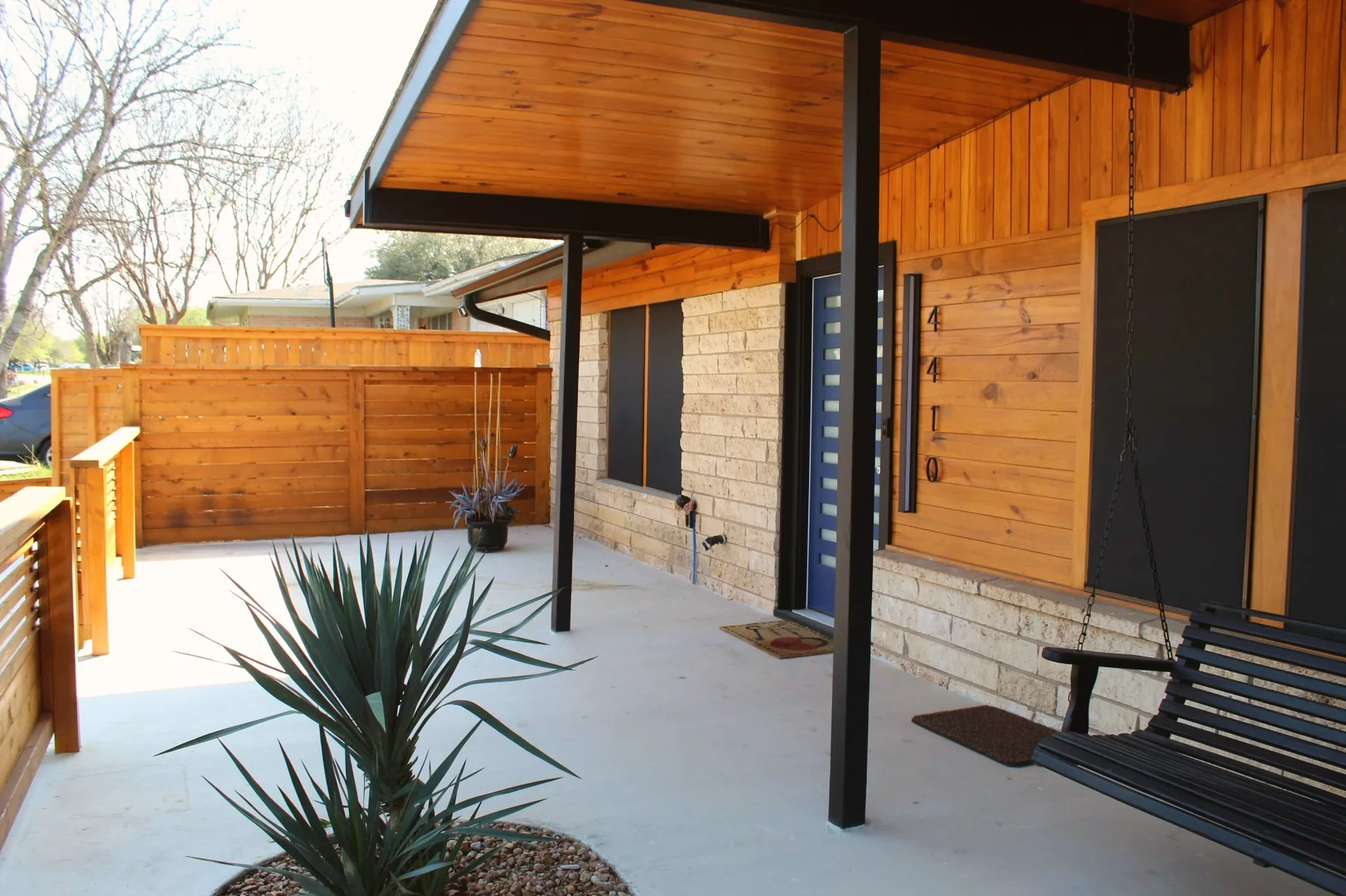 Wood privacy fence stained warm cedar tone beside residential sidewalk